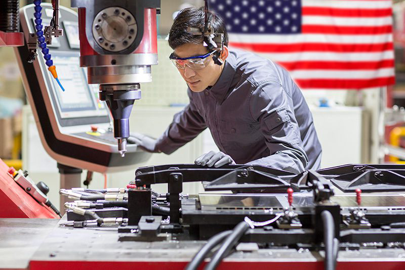 Engineer reviewing a custom tooling fixture used to improve manufacturing repeatability and automation readiness