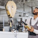 engineer working in a factory with hoisting and below the hook lifting equipment