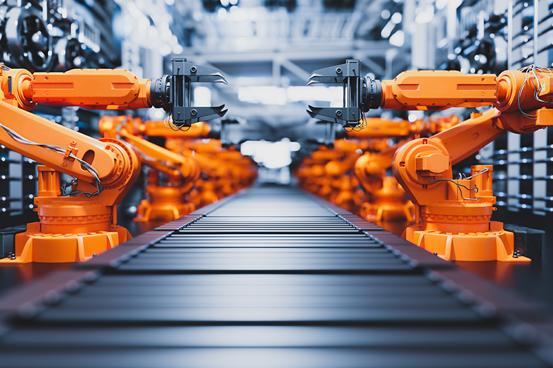 Robotic arms along assembly line in modern factory.